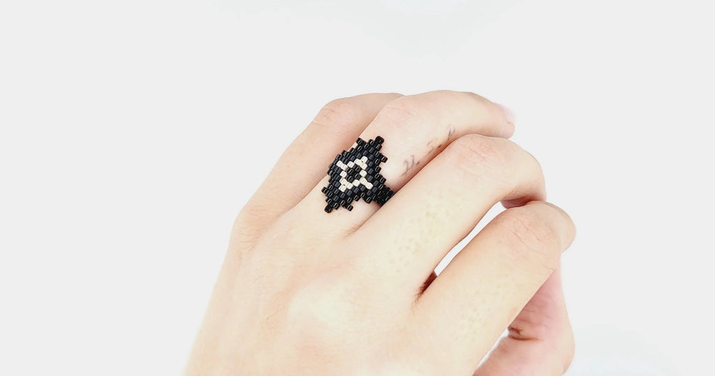 Modelo con un anillo cosido con cristal japonés negro brillante, mate y plateado