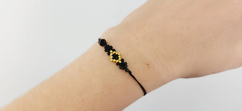 Modelo con una pulsera cosida con cristal japonés negro brillante, matizado y dorado